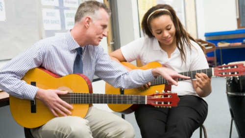 Photo of guitar teacher and student